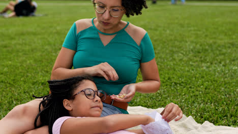 Woman-and-girl-doing-a-picnic-and-eating-popcorn